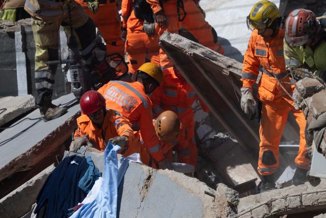 Minas Gerais' firefighters work at a collapsed nursing home in Belo Horizonte, Minas Gerais State, Brazil on March 5, 2026. A collapse at a nursing home in the southeastern Brazilian city of Belo Horizonte left at least two people dead on March 5, 2026, while firefighters worked to rescue 10 other victims from the rubble. (Photo by DOUGLAS MAGNO / AFP)
