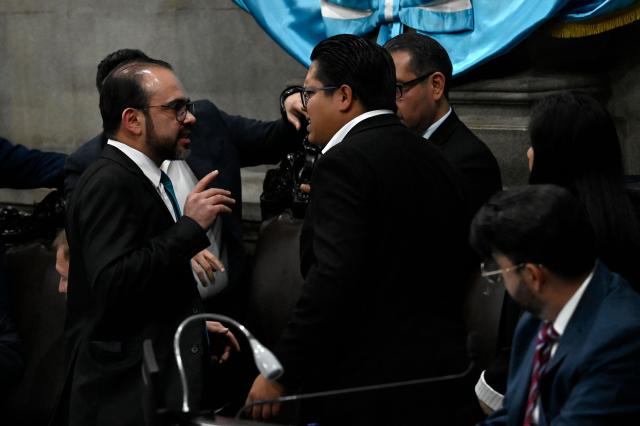 Guatemala's Congress second president Elmer Palencia (L) argues with deputy David Illescas (C) during a Congress session for the election of two magistrates for the Constitutional Court in Guatemala City on March 5, 2026. (Photo by JOHAN ORDONEZ / AFP)