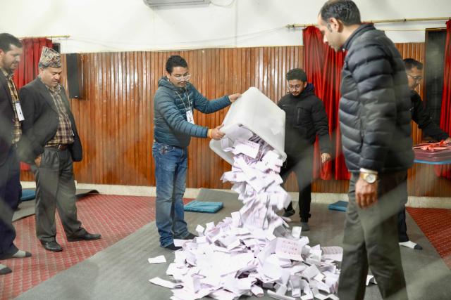 Electoral officials empty ballot boxes on the floor to start counting votes at the counting centre after voting ended in Nepal's general election in Kathmandu on March 5, 2026. Nepal voted on March 5 for a new parliament in a high-stakes showdown between an entrenched old guard and a powerful youth movement, six months after deadly anti-corruption protests toppled the government. (Photo by PRABIN RANABHAT / AFP)