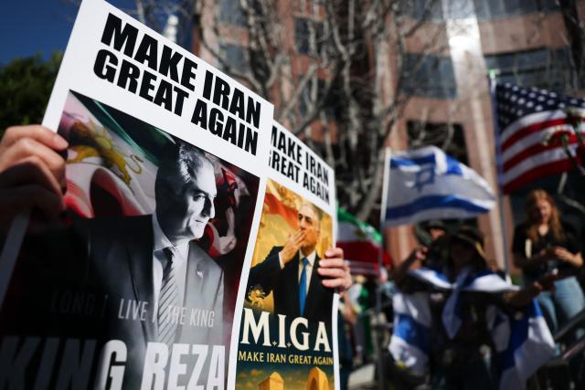 People hold "Make Iran Great Again" signs in support of Reza Pahlavi, son of the last shah of Iran, as they wave flags and chant during a gathering of Iranian community members showing support for Israel and the United States, outside the Consulate General of Israel in Los Angeles, on March 5, 2026. (Photo by Patrick T. Fallon / AFP)