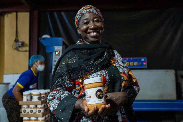 Mamana Dauda, 50, holds the Nutzy Mothers of Chibok product line during a visit to the factory in Lagos on February 27, 2026. Nine women from Chibok are collaborating with Zenfix Nigeria, a company that sells peanuts and nut products, and Arjena Foods, producer of the Nutzy peanut butter brand, which is very popular in Nigeria. 
This partnership was supported by Joel Kachi Benson, director of the documentary "Mothers of Chibok," released in theaters last week, which chronicles the lives of these mothers. 
Before the creation of Mothers of Chibok, their harvests were sold unprocessed to middlemen in the village, generating meager and unpredictable incomes. Today, they work has better value, they obtain a stable income, and reach a wider audience. 
These women's peanut production increased from 15 100kg bags to 27 bags between 2024 and 2025.
For Ajrena Foods and Zenfix Nigeria, the initiative is part of a social and economic reconstruction project that could inspire other mothers whose children have also been abducted by Boko Haram, other jihadist groups, or criminal gangs. (Photo by TOYIN ADEDOKUN / AFP)