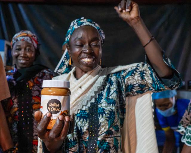 Lydia Yama, 47, holds a Nutzy Mothers of Chibok product line item from their collaboration during a visit to the factory in Lagos on February 27, 2026. Nine women from Chibok are collaborating with Zenfix Nigeria, a company that sells peanuts and nut products, and Arjena Foods, producer of the Nutzy peanut butter brand, which is very popular in Nigeria. 
This partnership was supported by Joel Kachi Benson, director of the documentary "Mothers of Chibok," released in theaters last week, which chronicles the lives of these mothers. 
Before the creation of Mothers of Chibok, their harvests were sold unprocessed to middlemen in the village, generating meager and unpredictable incomes. Today, they work has better value, they obtain a stable income, and reach a wider audience. 
These women's peanut production increased from 15 100kg bags to 27 bags between 2024 and 2025.
For Ajrena Foods and Zenfix Nigeria, the initiative is part of a social and economic reconstruction project that could inspire other mothers whose children have also been abducted by Boko Haram, other jihadist groups, or criminal gangs. (Photo by TOYIN ADEDOKUN / AFP)