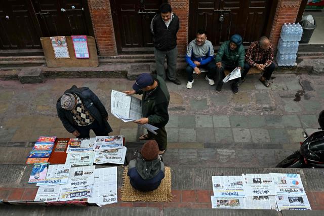 Men read newspapers at a stall in Kathmandu on March 6, 2026 a day after Nepal's Parliamentary election. Counting was underway in Nepal on March 6, after a high-stakes parliamentary election that could reshape the country's leadership following 2025 protests that toppled the government. (Photo by TAUSEEF MUSTAFA / AFP)