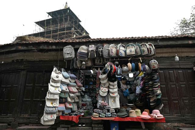 A shopkeeper stands inside her shop along a street in Kathmandu on March 6, 2026 a day after Nepal's Parliamentary election. Counting was underway in Nepal on March 6, after a high-stakes parliamentary election that could reshape the country's leadership following 2025 protests that toppled the government. (Photo by TAUSEEF MUSTAFA / AFP)