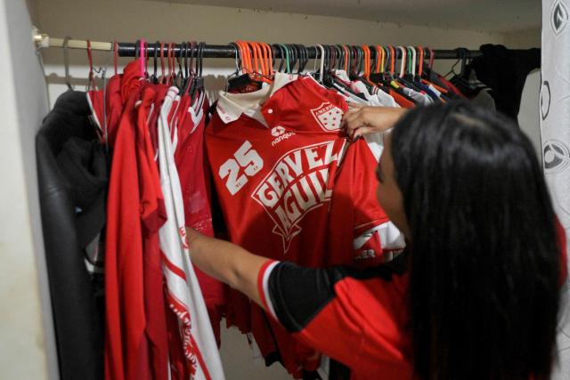 America de Cali's fan, Jessica Avila from the Colectivo Futbolero Escarlata, gets ready to attend the Copa Sudamericana football match between Colombia's America de Cali and Atletico Bucaramanga at the Olimpico Pascual Guerrero Stadium in Cali, Colombia on March 5, 2026. With a drum, a female fan sets the pace for the chants of a feminist fan club at the stadium in the Colombian city of Manizales. "One, two, three!" she says like an orchestra conductor surrounded exclusively by women tired of machismo in football, as is the case in other countries such as Brazil. (Photo by JOAQUIN SARMIENTO / AFP)
