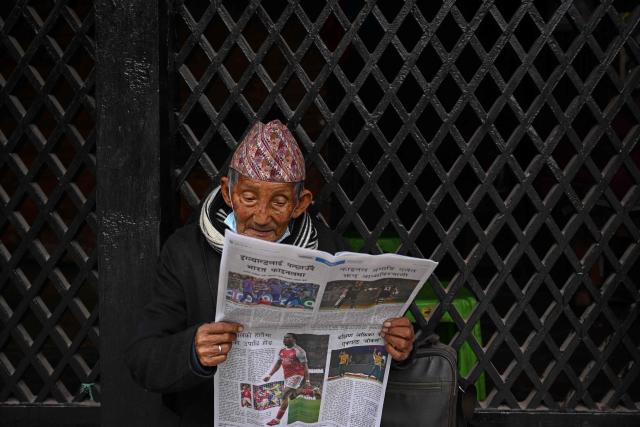 A man reads a newspaper at the Durbar Square in Kathmandu on March 6, 2026 a day after Nepal's Parliamentary election. Counting was underway in Nepal on March 6, after a high-stakes parliamentary election that could reshape the country's leadership following 2025 protests that toppled the government. (Photo by Prakash MATHEMA / AFP)