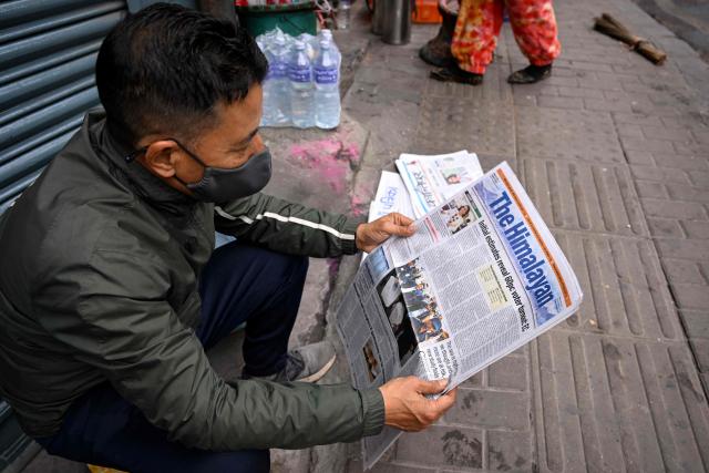A man reads a newspaper in Kathmandu on March 6, 2026 a day after Nepal's Parliamentary election. Counting was underway in Nepal on March 6, after a high-stakes parliamentary election that could reshape the country's leadership following 2025 protests that toppled the government. (Photo by Prakash MATHEMA / AFP)