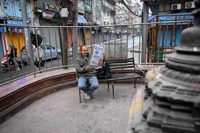 A man reads a newspaper in Kathmandu on March 6, 2026 a day after Nepal's Parliamentary election. Counting was underway in Nepal on March 6, after a high-stakes parliamentary election that could reshape the country's leadership following 2025 protests that toppled the government. (Photo by Prakash MATHEMA / AFP)