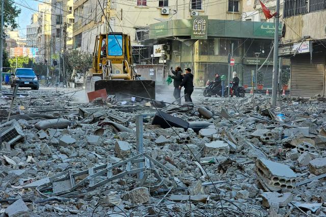 TOPSHOT - Workers use a bulldozer to clear debris from a street at the site of overnight Israeli airstrikes in the southern suburbs of Beirut on March 6, 2026. Heavy attacks were reported in Tehran on March 6 after Israel said it was hitting "regime infrastructure" in a "new phase" of the war it launched with the United States against Iran. As the conflict entered its seventh day, its regional repercussions continued -- with Qatar saying it intercepted a drone targeting a US base, and Lebanon reporting the death toll from Israeli strikes had risen to 123. (Photo by AFP)