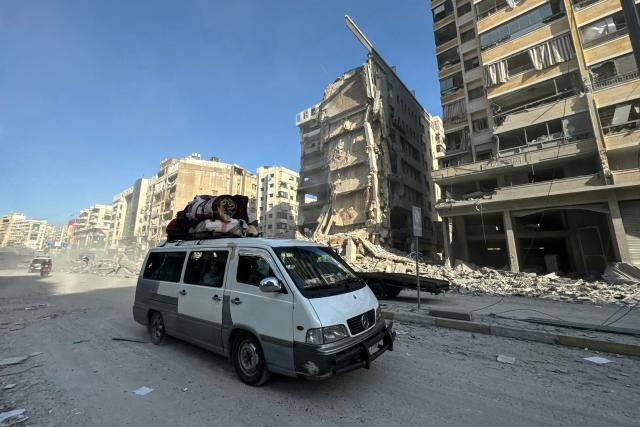 A van drives past buildings damaged in overnight Israeli airstrikes in the southern suburbs of Beirut on March 6, 2026. Heavy attacks were reported in Tehran on March 6 after Israel said it was hitting "regime infrastructure" in a "new phase" of the war it launched with the United States against Iran. As the conflict entered its seventh day, its regional repercussions continued -- with Qatar saying it intercepted a drone targeting a US base, and Lebanon reporting the death toll from Israeli strikes had risen to 123. (Photo by AFP)