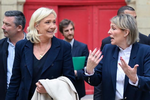 EDITORS NOTE: Graphic content / President of the far-right Rassemblement National (RN) parliamentary group Marine Le Pen (L) listens to French far-right party Rassemblement National (RN)'s mayoral candidate of Bourg-Saint-Andeol Celine Porquet (R) during a campaign visit, ahead of France's upcoming municipal elections in Bourg-Saint-Andeol, southern France on March 6, 2026. French voters head to the polls for municipal elections on March 15 and 22, 2026. (Photo by Miguel MEDINA / AFP)