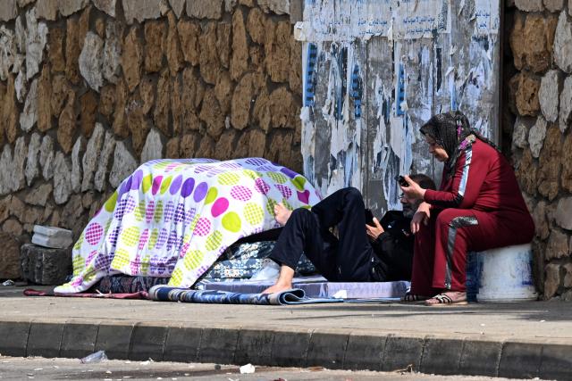 Displaced residents who fled Israeli airstrikes in Beirut's southern suburbs sit along the corniche waterfront in the Lebanese capital on March 6, 2026. Fresh strikes rocked Iran and Lebanon on March 6, as Israel vowed to escalate to a new phase in the Middle East war that has spiralled rapidly throughout the region and beyond. (Photo by Joseph EID / AFP)