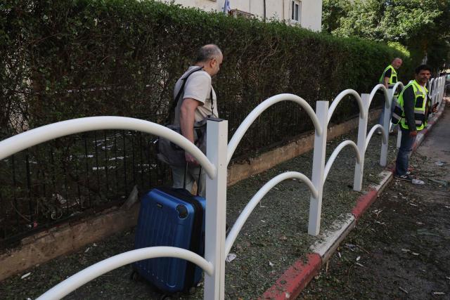 A man leaves after a building he reside in was damaged following an Iranian strike in Givatayim, in the center of Israel on March 6, 2026. The war broke out on February 28 after US and Israeli strikes on Iran which responded by attacking US bases in Gulf countries and mainland Israel with drone and missiles strikes. (Photo by Jack GUEZ / AFP)