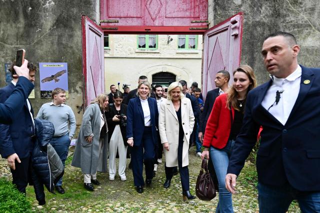 EDITORS NOTE: Graphic content / President of the far-right Rassemblement National (RN) parliamentary group Marine Le Pen (C) walks with French far-right party Rassemblement National (RN)'s mayoral candidate of Bourg-Saint-Andeol Celine Porquet (C-L) during a campaign visit ahead of France's upcoming municipal elections in Bourg-Saint-Andeol, southern France on March 6, 2026. French voters head to the polls for municipal elections on March 15 and 22, 2026. (Photo by Miguel MEDINA / AFP)