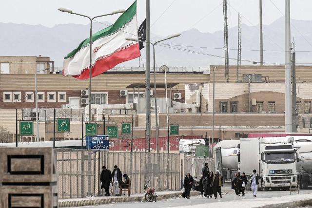 TOPSHOT - Pakistani nationals walk across the Taftan border as they return from Iran, in Balochistan province, on March 6, 2026 amid ongoing US-Israel strikes on Iran. Pakistani nationals hauled suitcases across the border from neighbouring Iran, describing missiles being launched and travel chaos as they scrambled to leave the country that the United States and Israel hit with strikes over the last weekend. (Photo by Banaras KHAN / AFP)