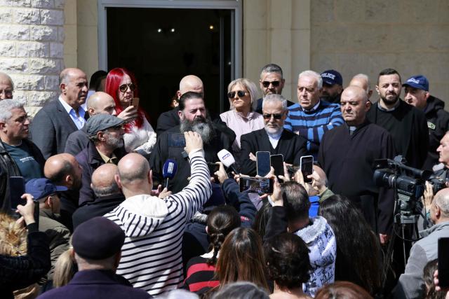 Residents of the southern Lebanese border town of Marjeyoun gather to listen to thei priest in the town's churchyard to assert their intention not to leave their homes as directed by the Israeli military earlier this week on March 6, 2026. Fresh strikes rocked Iran and Lebanon on March 6, as Israel vowed to escalate to a new phase in the Middle East war that has spiralled rapidly throughout the region and beyond. (Photo by Rabih DAHER / AFP)
