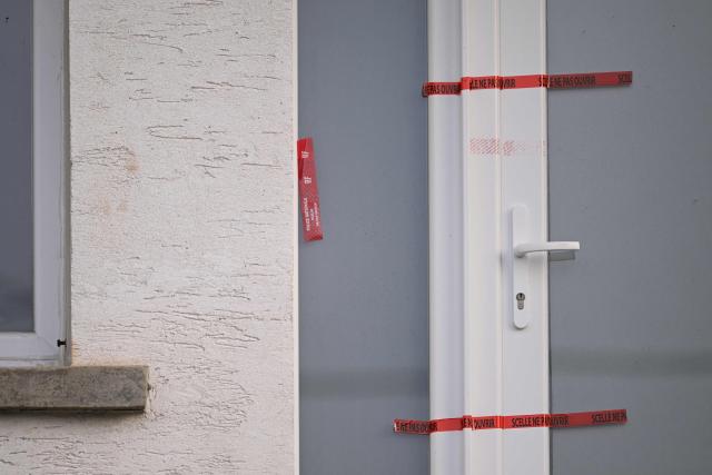This photograph shows Police tape on the sealed door at the home of Liliane Coinchelin's youngest son suspected to have held his mother captive for several months leading to her death in Saint-Michel-sur-Meurthe, eastern France on March 6, 2026. A 39-year-old man has been charged with torture and barbaric acts resulting in the death of his mother, who died at least three years ago, the public prosecutor in Epinal, in the Vosges region, announced on March 6, 2026. The deceased woman's eldest son, aged 45, and his partner, aged 40, have been charged with complicity in acts of torture and barbarity resulting in death, unlawful confinement by an organised gang, and organised fraud. An investigation into her disappearance was launched after the mayor of Saint-Michel-sur-Meurthe reported on January 28, 2026 that Liliane Coinchelin, a resident of this village of some 1,700 inhabitants near Saint-Die-des-Vosges, had been missing for at least three years. (Photo by SEBASTIEN BOZON / AFP)
