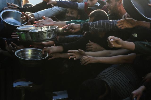 Displaced Palestinians jostle for food at a food bank in Khan Yunis, in the south of the Gaza Strip on March 6, 2026. The majority of Gaza's 2.4 million people have been displaced, often multiple times, by the war that began with Hamas's attack on southern Israel on October 7, 2023. With displaced families living in tented camps, with serious concerns raised over their living conditions. (Photo by Bashar Taleb / AFP)