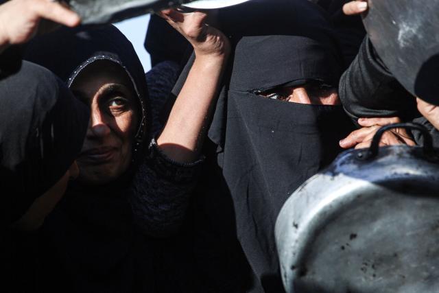 Displaced Palestinian women jostle for food at a food bank in Khan Yunis, in the south of the Gaza Strip on March 6, 2026. The majority of Gaza's 2.4 million people have been displaced, often multiple times, by the war that began with Hamas's attack on southern Israel on October 7, 2023. With displaced families living in tented camps, with serious concerns raised over their living conditions. (Photo by Bashar Taleb / AFP)