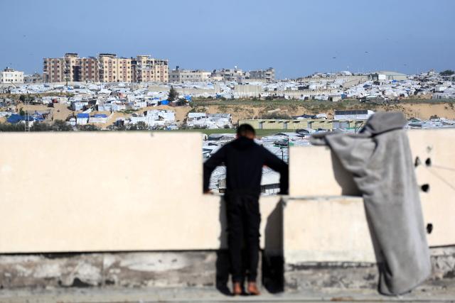 A boy looks out over hundreds of tents are set up to house displaced Palestinians who lost their homes and businesses during Israeli military bombardment of the Gaza Strip, in Khan Yunis, in the south of the Gaza Strip on March 6, 2026. The majority of Gaza's 2.4 million people have been displaced, often multiple times, by the war that began with Hamas's attack on southern Israel on October 7, 2023. With displaced families living in tented camps, with serious concerns raised over their living conditions. (Photo by Bashar Taleb / AFP)