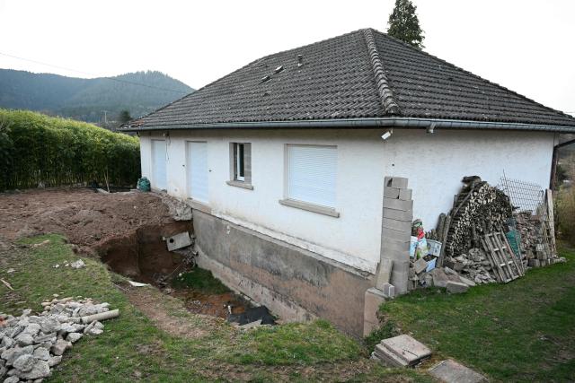 This photograph shows the excavated garden belonging to Liliane Coinchelin's youngest son in Saint-Michel-sur-Meurthe, eastern France, on March 6, 2026, as part of the search for the body of Liliane Coinchelin whose son is suspected to have held his mother captive for several months. A 39-year-old man has been charged with torture and barbaric acts resulting in the death of his mother, who died at least three years ago, the public prosecutor in Epinal, in the Vosges region, announced on March 6, 2026. The deceased woman's eldest son, aged 45, and his partner, aged 40, have been charged with complicity in acts of torture and barbarity resulting in death, unlawful confinement by an organised gang, and organised fraud. An investigation into her disappearance was launched after the mayor of Saint-Michel-sur-Meurthe reported on January 28, 2026 that Liliane Coinchelin, a resident of this village of some 1,700 inhabitants near Saint-Die-des-Vosges, had been missing for at least three years. (Photo by SEBASTIEN BOZON / AFP)