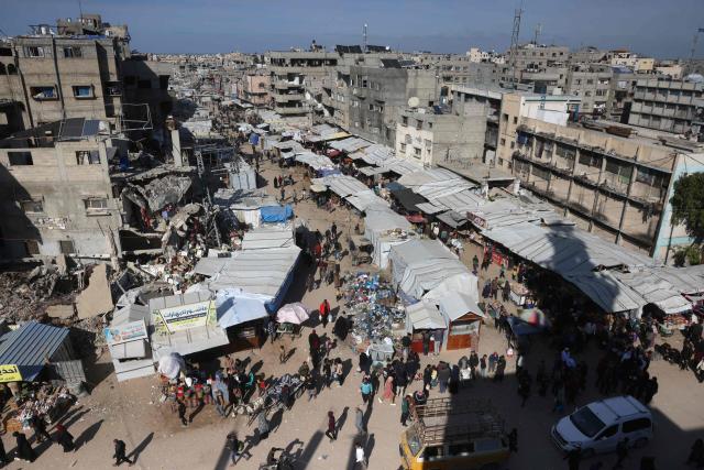 Displaced Palestinians who lost their homes and businesses during Israeli military bombardment of the Gaza Strip, shop in a market set-up close to destroyed buildings in Khan Yunis, in the south of the Gaza Strip on March 6, 2026. The majority of Gaza's 2.4 million people have been displaced, often multiple times, by the war that began with Hamas's attack on southern Israel on October 7, 2023. With displaced families living in tented camps, with serious concerns raised over their living conditions. (Photo by Bashar Taleb / AFP)