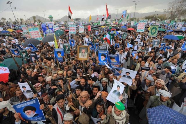 Houthi supporters brandish rifles and hold portraits of Iran's slain supreme leader Ayatollah Ali Khamenei during a rally in solidarity with Iran and Lebanon, amid the US-Israeli conflict with Iran, in the Yemeni capital Sanaa on March 6, 2026. The US president on March 6, demanded Iran's "unconditional surrender" as the only acceptable outcome to end hostilities, while promising to help rebuild the country's economy if Tehran complied. (Photo by Mohammed HUWAIS / AFP)
