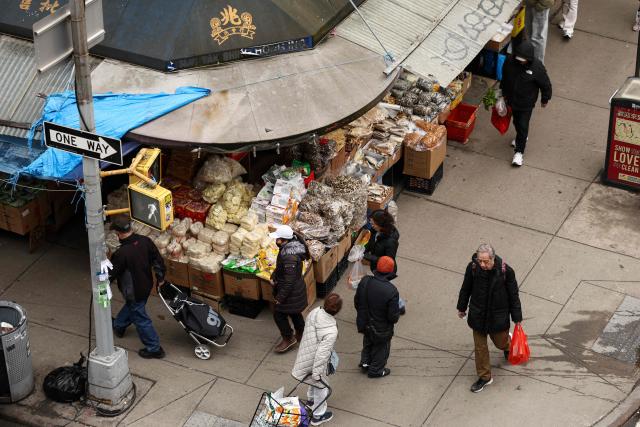 People shop and move along a street of Chinatown in the Manhattan borough of New York City on March 6, 2026. (Photo by CHARLY TRIBALLEAU / AFP)