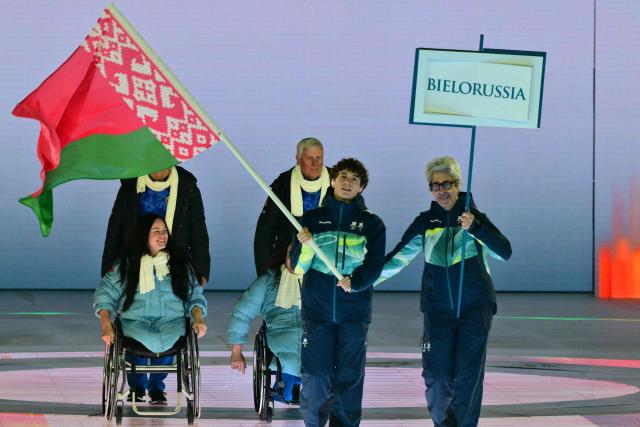 A volunteer holds the flag of Bielorussia during the delegation parade of the Milano Cortina 2026 Winter Paralympic Games opening ceremony at Arena di Verona in Verona on March 6, 2026. (Photo by Stefano RELLANDINI / AFP)