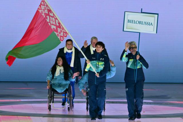 A volunteer holds the flag of Bielorussia during the delegation parade of the Milano Cortina 2026 Winter Paralympic Games opening ceremony at Arena di Verona in Verona on March 6, 2026. (Photo by Stefano RELLANDINI / AFP)
