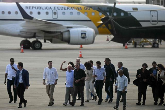 Brazil's President Luiz Inacio Lula da Silva (C) and Rio de Janeiro's Mayor Eduardo Paes (C R), along with other authorities walk on the tarmac during the airport hub inauguration at the Galeao–Antonio Carlos Jobim International Airport in Rio de Janeiro, Brazil, on March 6, 2026. (Photo by Mauro PIMENTEL / AFP)
