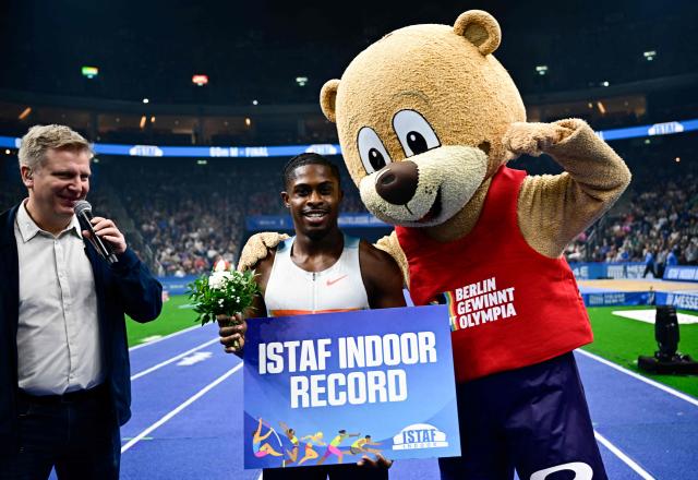 Britain's Jeremiah Azu poses with the mascot and the "ISTAF Indoor Record" sign after the men's 60m event of the ISTAF indoor Athletics Meeting 2026 in Berlin on March 6, 2026. (Photo by Tobias SCHWARZ / AFP)