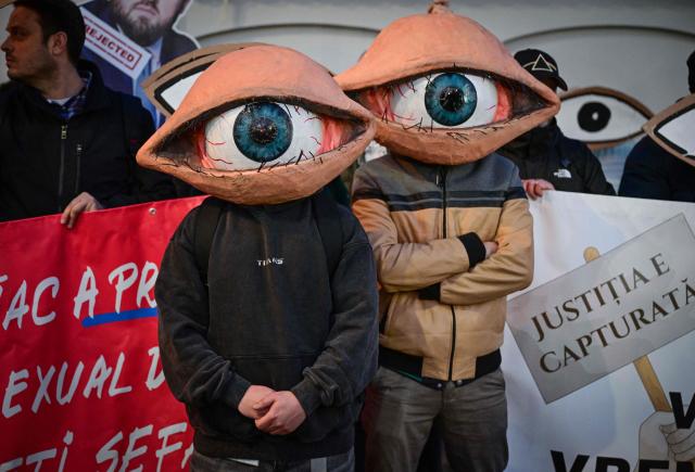 Protesters wearing eye-masks gather in front of the Cotroceni Palace, the headquarters of the Romanian Presidency, during a demonstration called "We see you" against new proposals for the leadership of major prosecutor's offices in Bucharest March 6, 2025. Organized in response to candidates put forward by the Ministry of Justice, demonstrators called for judicial independence and transparency in the appointment process of the prosecutors. (Photo by Daniel MIHAILESCU / AFP)