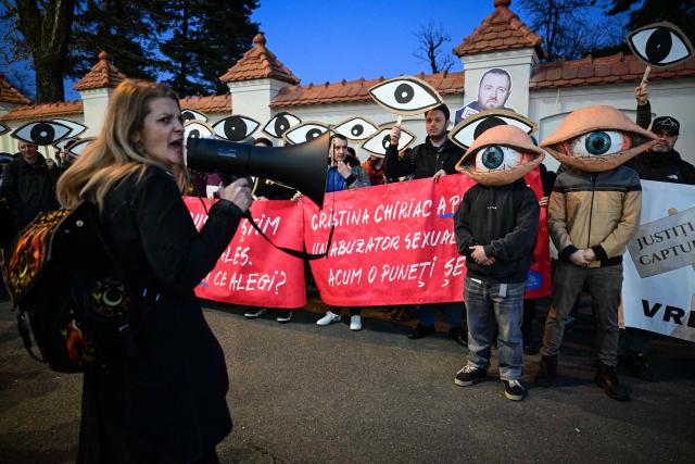Protesters wearing eye-masks gather in front of the Cotroceni Palace, the headquarters of the Romanian Presidency, during a demonstration called "We see you" against new proposals for the leadership of major prosecutor's offices in Bucharest March 6, 2025. Organized in response to candidates put forward by the Ministry of Justice, demonstrators called for judicial independence and transparency in the appointment process of the prosecutors. (Photo by Daniel MIHAILESCU / AFP)