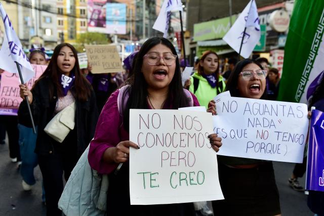 Young women shout slogans as they hold signs during a march against government on the eve of International Women's Day in La Paz on March 6, 2026. The International Women's Rights Day will fall on March 8, 2026. (Photo by Jorge BERNAL / AFP)