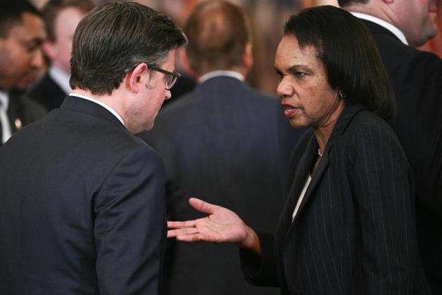 US Speaker of the house Mike Johnson (R-LA) speaks with former US Secretary of State Condoleezza Rice after a roundtable to "save college sports" in the East Room of the White House in Washington, DC, on March 6, 2026. (Photo by Brendan SMIALOWSKI / AFP)
