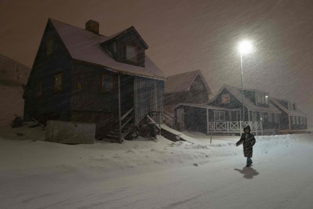 A person walks through heavy snowfall at night in the streets of Nuuk, Greenland, on March 6, 2026. (Photo by Florent VERGNES / AFP)