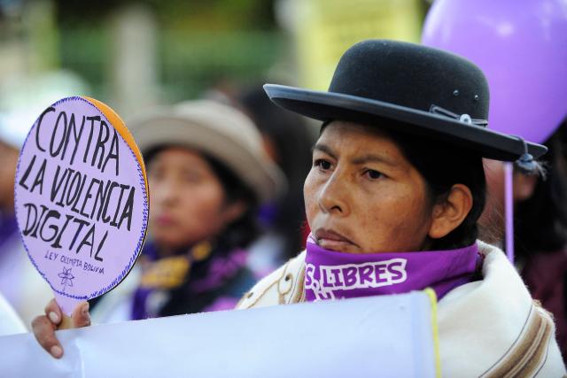 TOPSHOT - An indigenous woman holds a sign that reads in Spanish "Against digital violence" during a march against the government on the eve of International Women's Day in La Paz on March 6, 2026. The International Women's Rights Day will fall on March 8, 2026. (Photo by Jorge BERNAL / AFP)