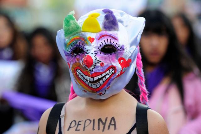 A feminist group member wears a mask during a march against the government on the eve of International Women's Day in La Paz on March 6, 2026. The International Women's Rights Day will fall on March 8, 2026. (Photo by Jorge BERNAL / AFP)