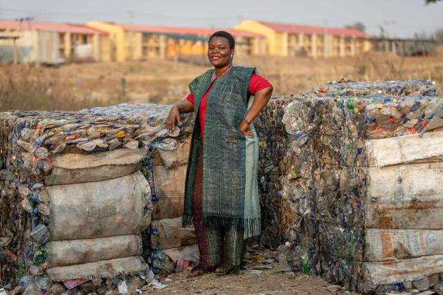 Rita Idehai, founder of Ecobarter, poses for a photograph beside stacked plastic bales at her facility in Abuja in Abuja on March 4, 2026. Rita Idehai launched her company, Ecobarter, in Abuja in 2018, building on an idea she developed in 2017 to turn waste into resources.
She also created the Waste Resource Empowerment Program, which helps women in local communities turn plastic waste into handwoven materials used to produce bags, clothing, and other fashion items.
Through her work, plastics that would otherwise contribute to environmental pollution are repurposed and reintroduced into society as fashionable accessories. Ecobarter also encourages people to exchange recyclable waste for useful items, creating a system that rewards responsible waste disposal while helping reduce plastic pollution in local communities. (Photo by Light Oriye Tamunotonye / AFP)