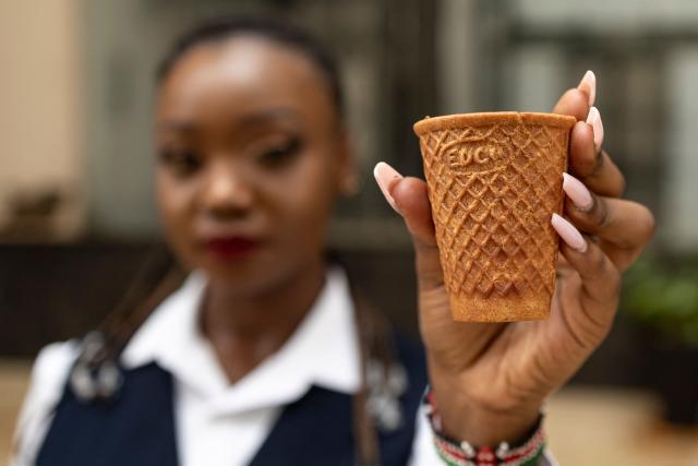 Kenyan innovator and ecopreneur, Sheryl Mboya, 26, poses with one of her innovations, an edible cup; an idea born of her dislike of plastic pollution in Nairobi on March 6, 2026. Christened 'snackuit', the law graduate's patented edible tableware is her answer to single-use plastics pollution and is alot safer for the general environment due to it's biodegradability.Developed under GreenX Telemechanics Limited, a technology and innovation developer whose core objective is to come up with innovative solutions such as Snackuit, that not only address challenges mankind face but also contribute to climate action. (Photo by Tony KARUMBA / AFP)