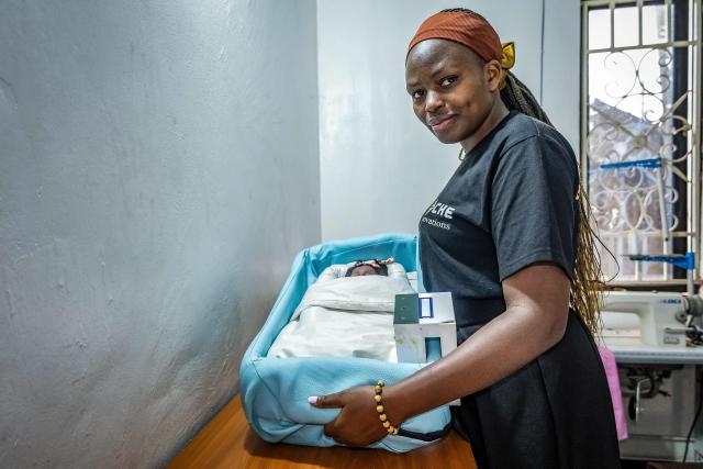 Vivian Arinaitwe, 24, a biomedical engineer and CEO of Che Innovations, displays a unit of NeoNest at their workspace in Kampala, on March 6, 2026. NeoNest is an award-winning, low-cost medical device developed by Che Innovations to prevent neonatal hypothermia during ambulance transfers from rural health facilities to referral hospitals. Designed for low-resource settings, the portable infant warmer helps maintain a stable temperature for preterm and low-birth-weight babies during transport, when they are most vulnerable to life-threatening heat loss. (Photo by Badru Katumba / AFP)