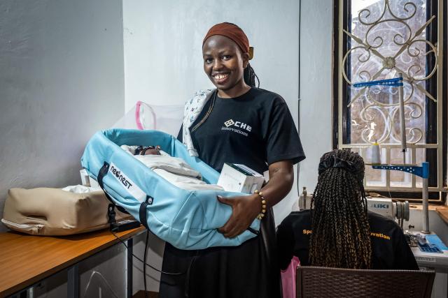 Vivian Arinaitwe, 24, a biomedical engineer and CEO of Che Innovations, displays a unit of NeoNest at their workspace in Kampala, on March 6, 2026. NeoNest is an award-winning, low-cost medical device developed by Che Innovations to prevent neonatal hypothermia during ambulance transfers from rural health facilities to referral hospitals. Designed for low-resource settings, the portable infant warmer helps maintain a stable temperature for preterm and low-birth-weight babies during transport, when they are most vulnerable to life-threatening heat loss. (Photo by Badru Katumba / AFP)