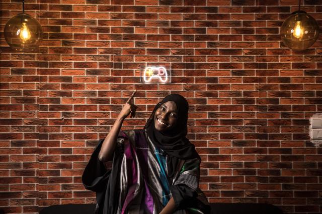 Game designer Mame Faty Kane poses for a portrait at the Game Hub in Dakar, on March 6, 2026. Mame Faty started playing video games at a young age. Instead of asking for dolls like her friends, she received a Game Boy from her parents. What began as a pastime slowly turned into a passion, and after finishing her studies, she began building her skills at Dakar’s Game Hub to become a game designer. To this day, she has created several video games, focusing mostly on educational ones like Cax Caxett (“find the riddle” in Wolof), where players can learn about Senegalese culture.“I can make my dreams come true when I create a video game. I’m always wondering, ‘Can I do this?’ and then I realize that there are no limits to what I can do as a game designer.” (Photo by PATRICK MEINHARDT / AFP)