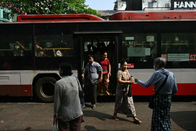Commuters alight from a bus on the first day of the implementation of an "odd-even" vehicle numbering system in Yangon on March 7, 2026. Myanmar's junta announced half of private vehicles will be ordered off the roads each day, based on licence plate numbers, in order to conserve fuel due to the war in the Middle East. Myanmar imports 90 percent of its fuel oil, according to 2024 figures, and has long suffered from a fragile energy supply chain owing to the civil war consuming the country since the military staged a coup five years ago. (Photo by Sai Aung MAIN / AFP)