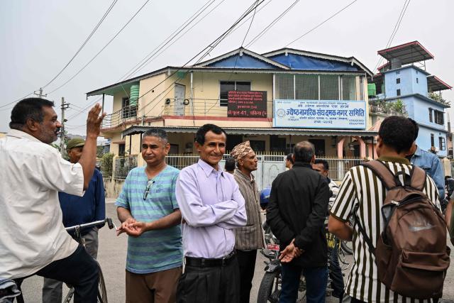 People gather near a digital screen displaying election results amid vote counting in Damak, Jhapa district, on March 7, 2026, two days after Nepal's parliamentary election. Nepal's centrist party of rapper-turned-politician Balendra Shah looked set to win by a landslide in parliamentary polls, according to Election Commission trends March 7, but with counting still far to go. (Photo by Prakash MATHEMA / AFP)