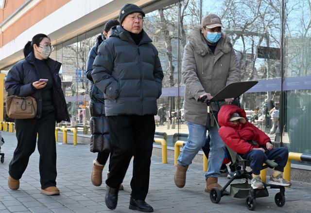 People enter a children's hospital in Beijing on March 6, 2026. (Photo by Adek BERRY / AFP)