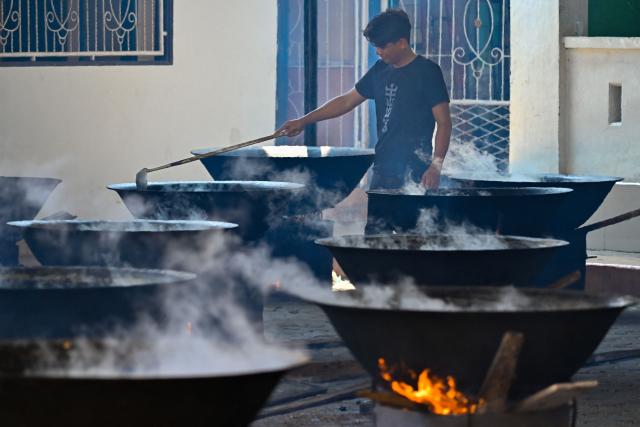 A man cooks traditional curry dishes called 'kuah beulangong' in cauldrons to be shared at iftar, to commemorate the revelation of the Quran during the Muslim holy month of Ramadan, in Banda Aceh on March 7, 2026. (Photo by CHAIDEER MAHYUDDIN / AFP)