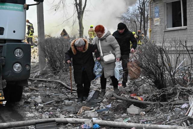 Residents leave the area after a five-story residential building was hit by a ballistic missile in Kharkiv on March 7, 2026 amid the Russian invasion of Ukraine. Russia pummelled Ukraine with drone and missile attacks overnight, killing six people and triggering air alerts across the country, officials said. The bodies of five people were found in the rubble of an apartment block in the eastern Kharkiv region, while one person was killed in the Dnipropetrovsk region. (Photo by SERGEY BOBOK / AFP)