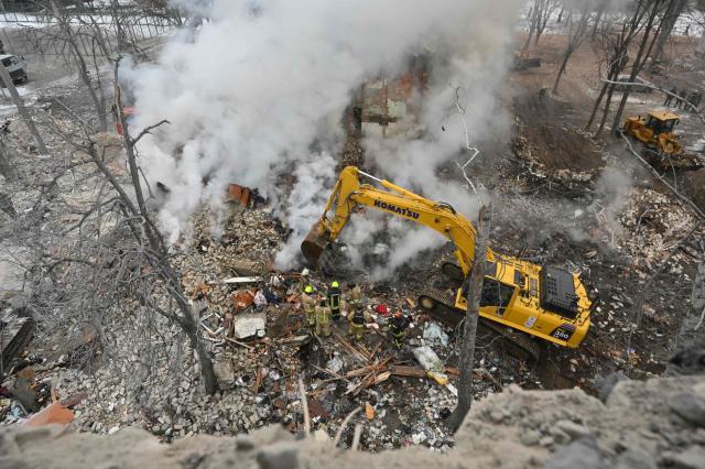 Rescuers search the rubbles of a five-story residential building which was hit by a ballistic missile in Kharkiv on March 7, 2026 amid the Russian invasion of Ukraine. Russia pummelled Ukraine with drone and missile attacks overnight, killing six people and triggering air alerts across the country, officials said. The bodies of five people were found in the rubble of an apartment block in the eastern Kharkiv region, while one person was killed in the Dnipropetrovsk region. (Photo by SERGEY BOBOK / AFP)